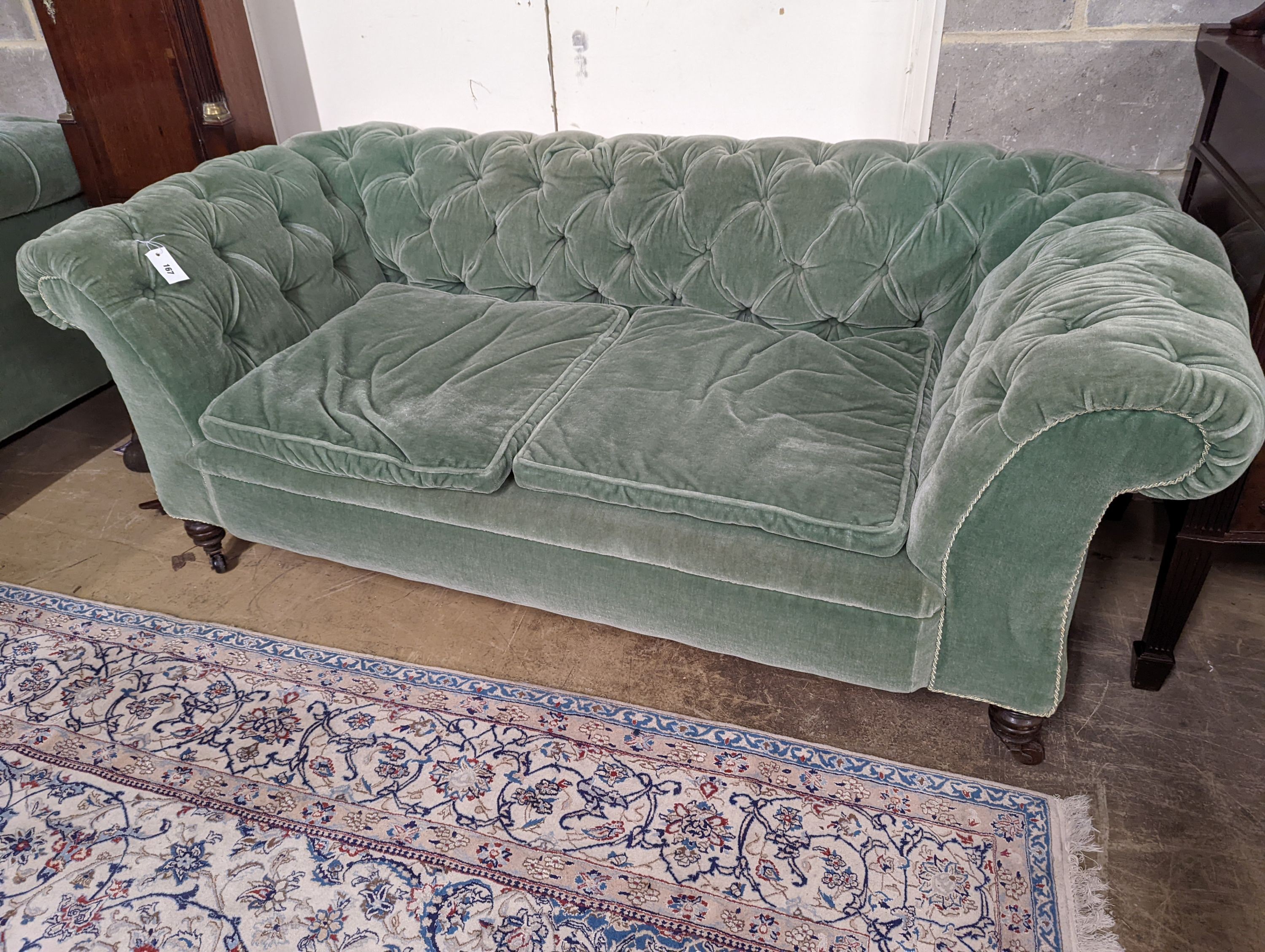 A late Victorian double drop arm Chesterfield settee upholstered in green fabric, length 186cm, depth 84cm, height 70cm